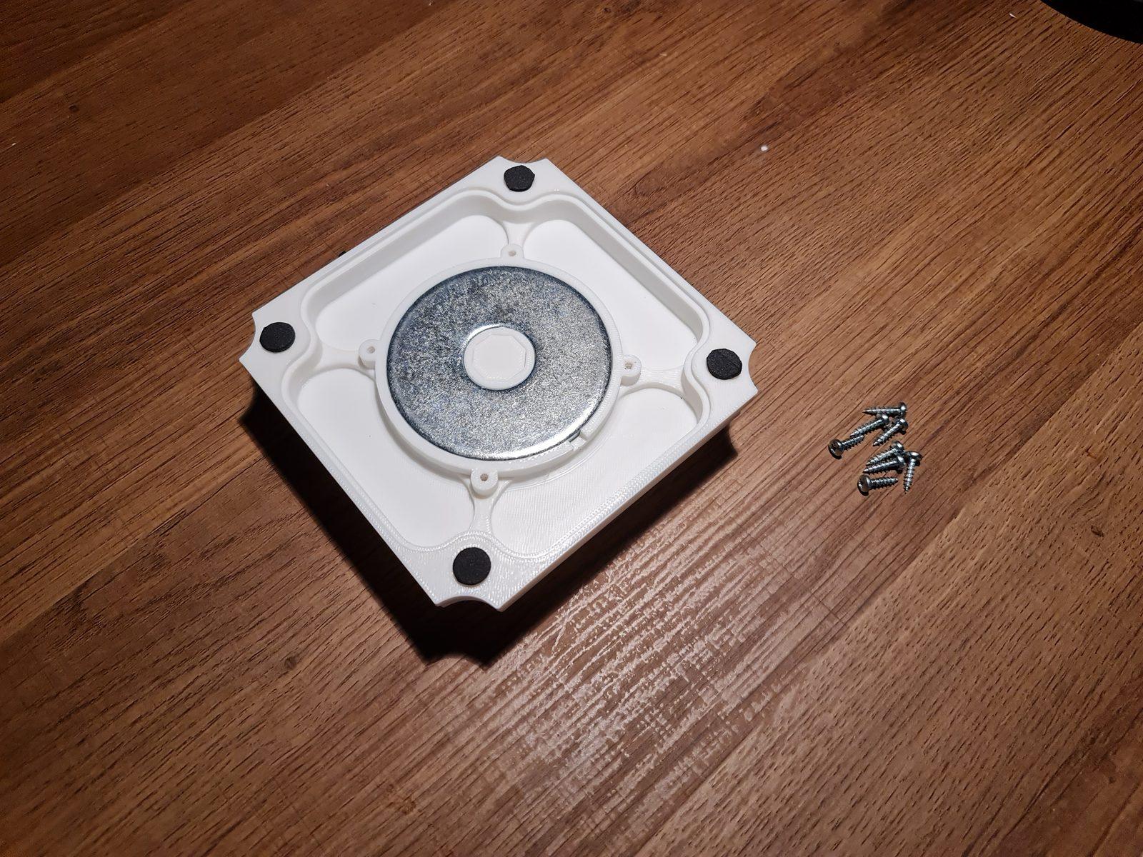 The base with the steel washer seated in the centre and a rubber foot in each corner