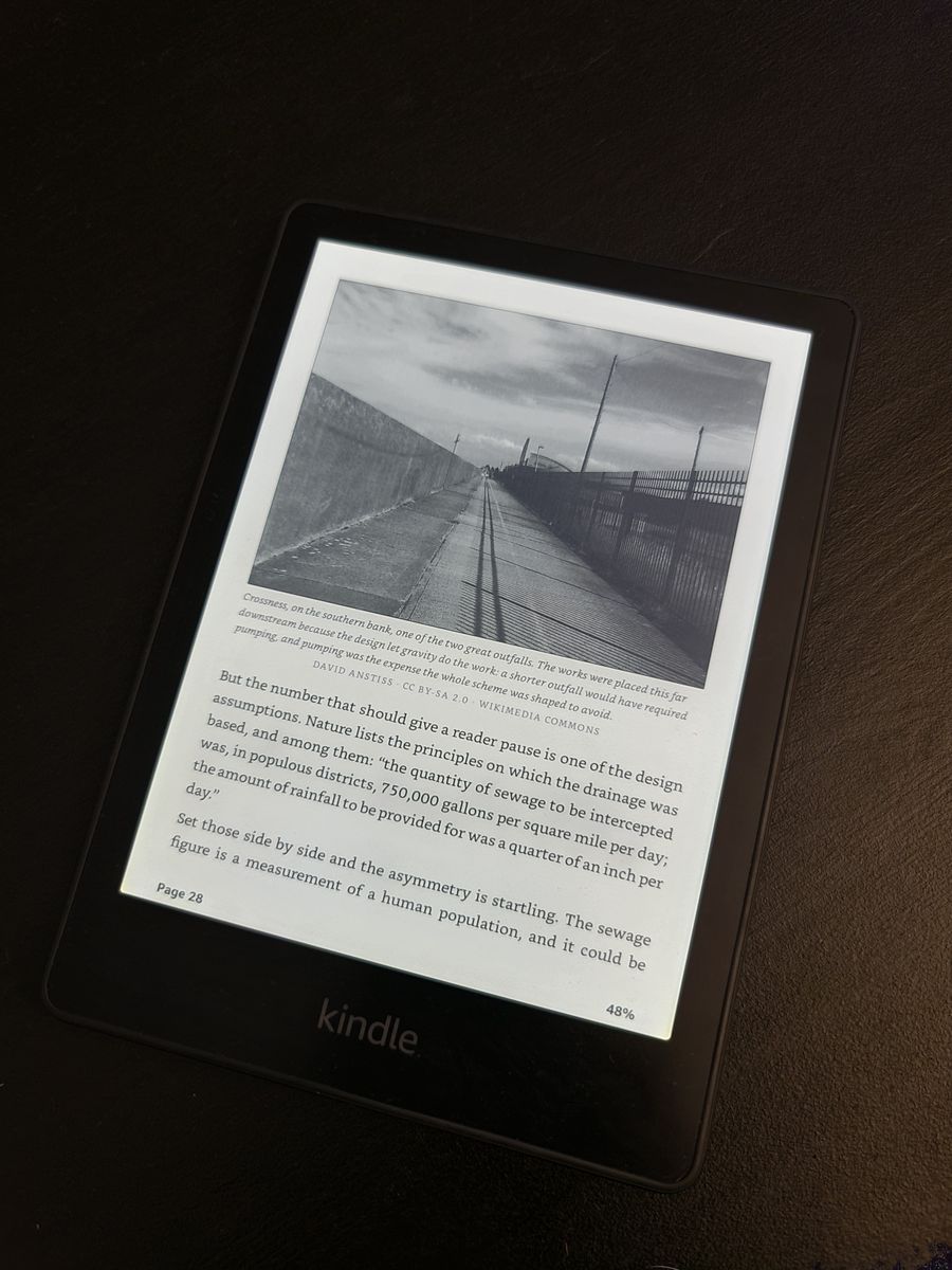 A Kindle page with a black-and-white photo of a long walkway beside a wall and a fence, captioned and credited to Wikimedia Commons under CC BY-SA 2.0